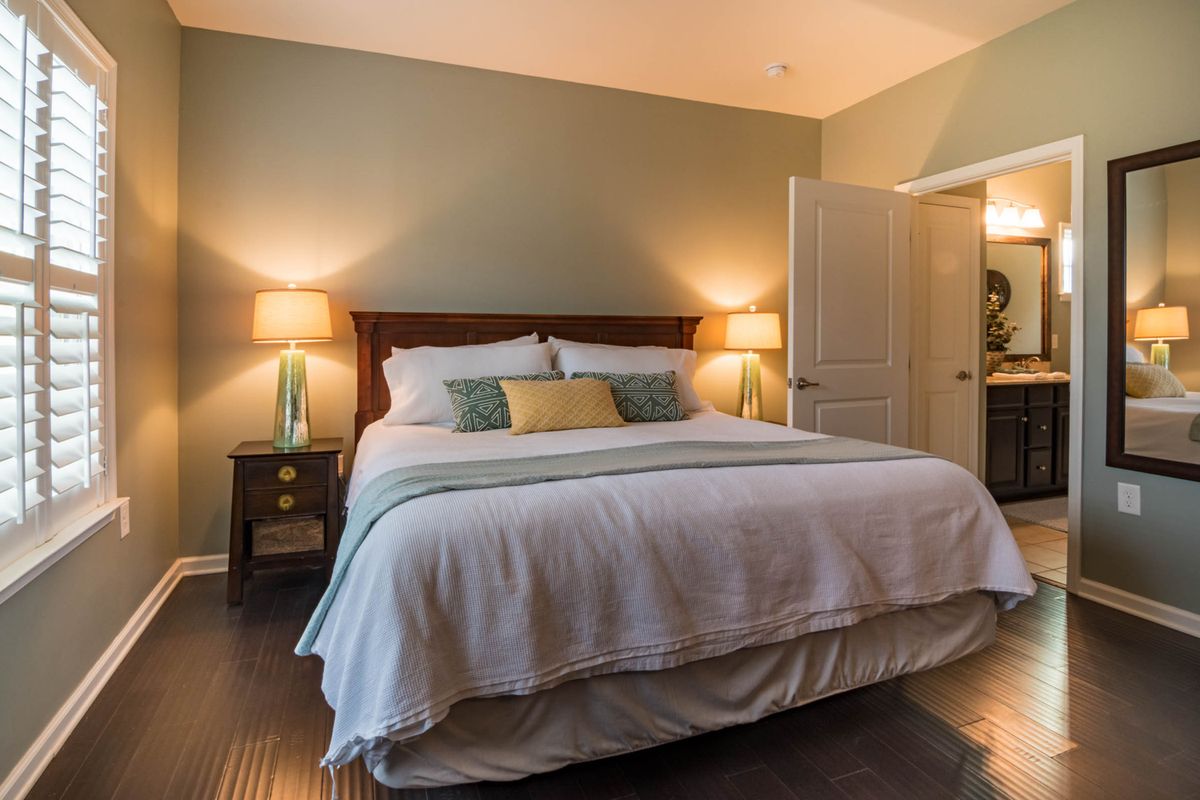 A comfortable bed in a warm, modern bedroom